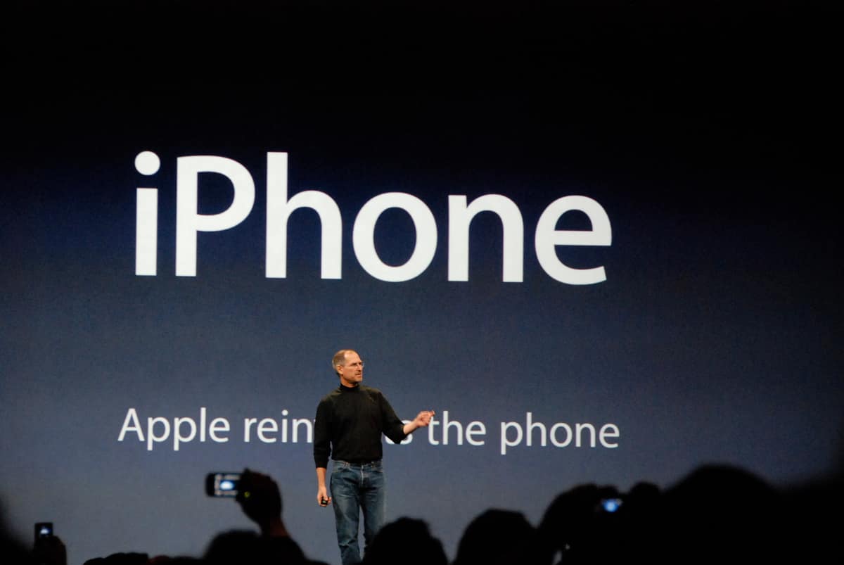 Steve Jobs on stage at Macworld 2007 in San Francisco, holding up the first iPhone during its unveiling.