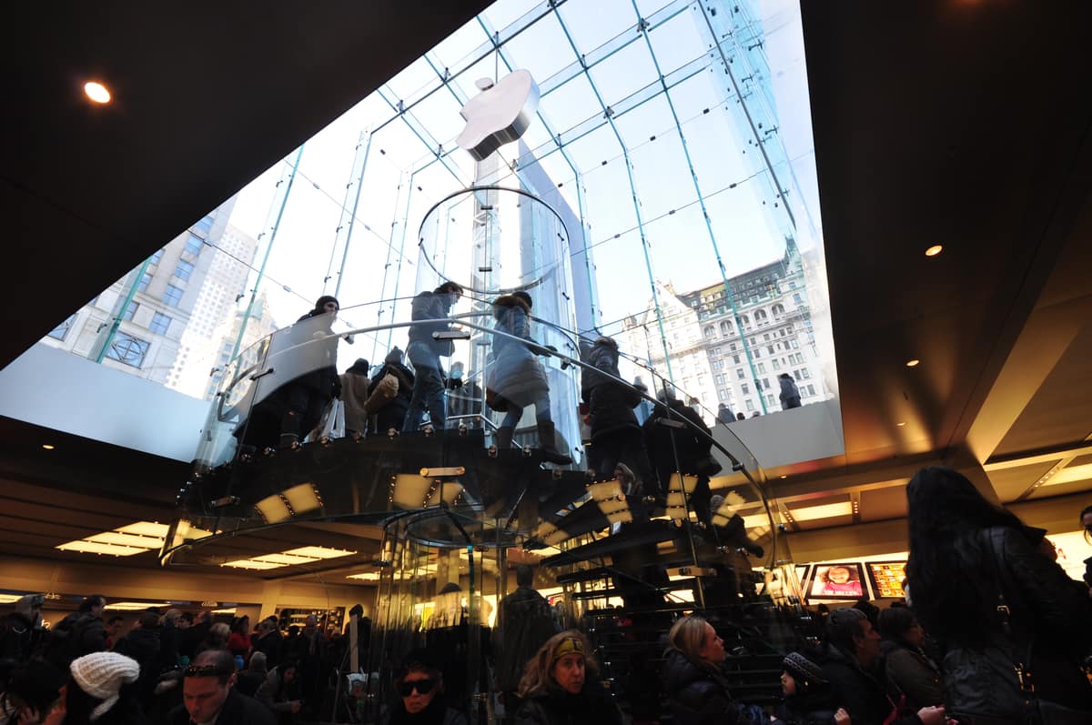 Interior of the Apple Store on Fifth Avenue in New York, looking up through the patented all-glass spiral staircase beneath the iconic glass cube entrance.